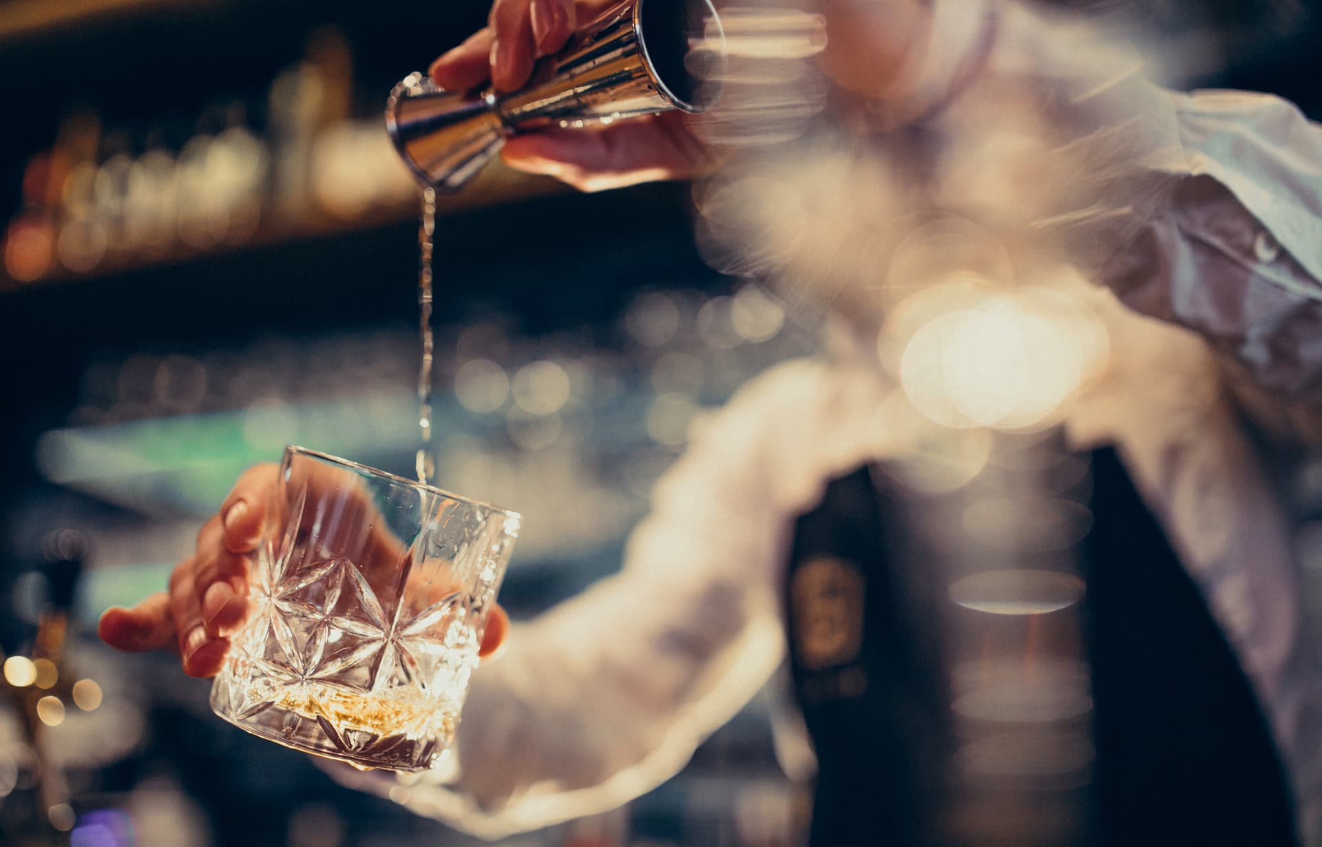 zdjęcie przedstawia drink nalewany przez barmana